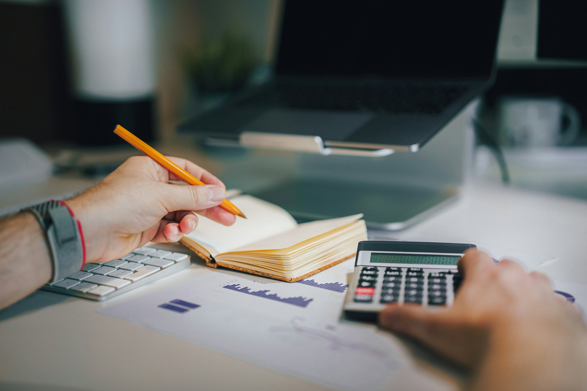 a-person-sitting-at-a-desk-with-a-calculator-and-a-notebook.jpg a person sitting at a desk with a calculator and a notebook